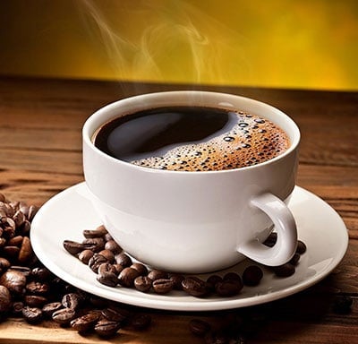 An image of a cup of coffee with beans