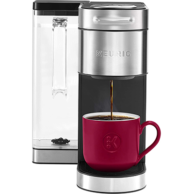 Front of Keurig K Supreme Plus with coffee dripping from its spout into a fuschia cup