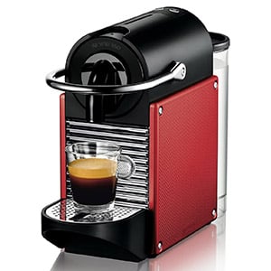 Nespresso Pixie D60 in a red case with a cup of coffee under its spout